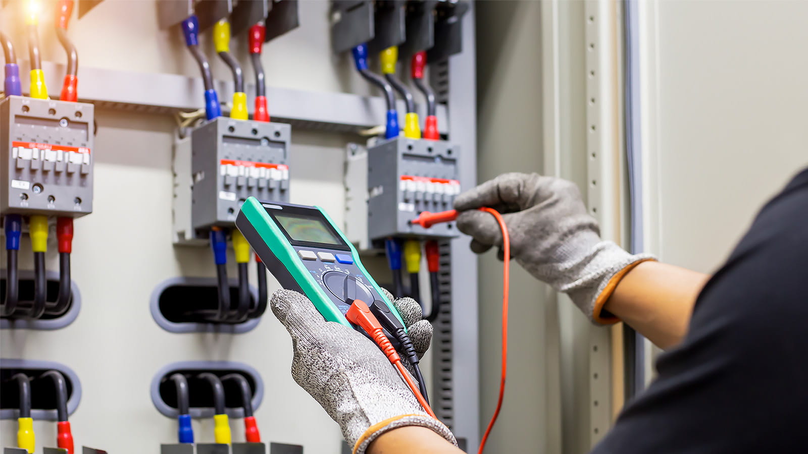 person engineer employee reading electrical meter with cables gloved hands