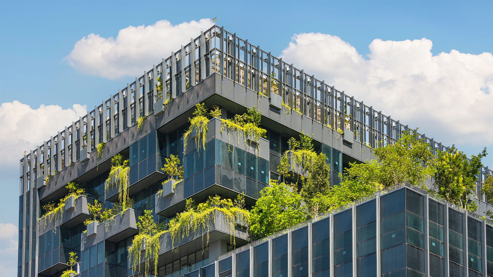 modern high rise building with trees and plants growing on the rooftops and balconies