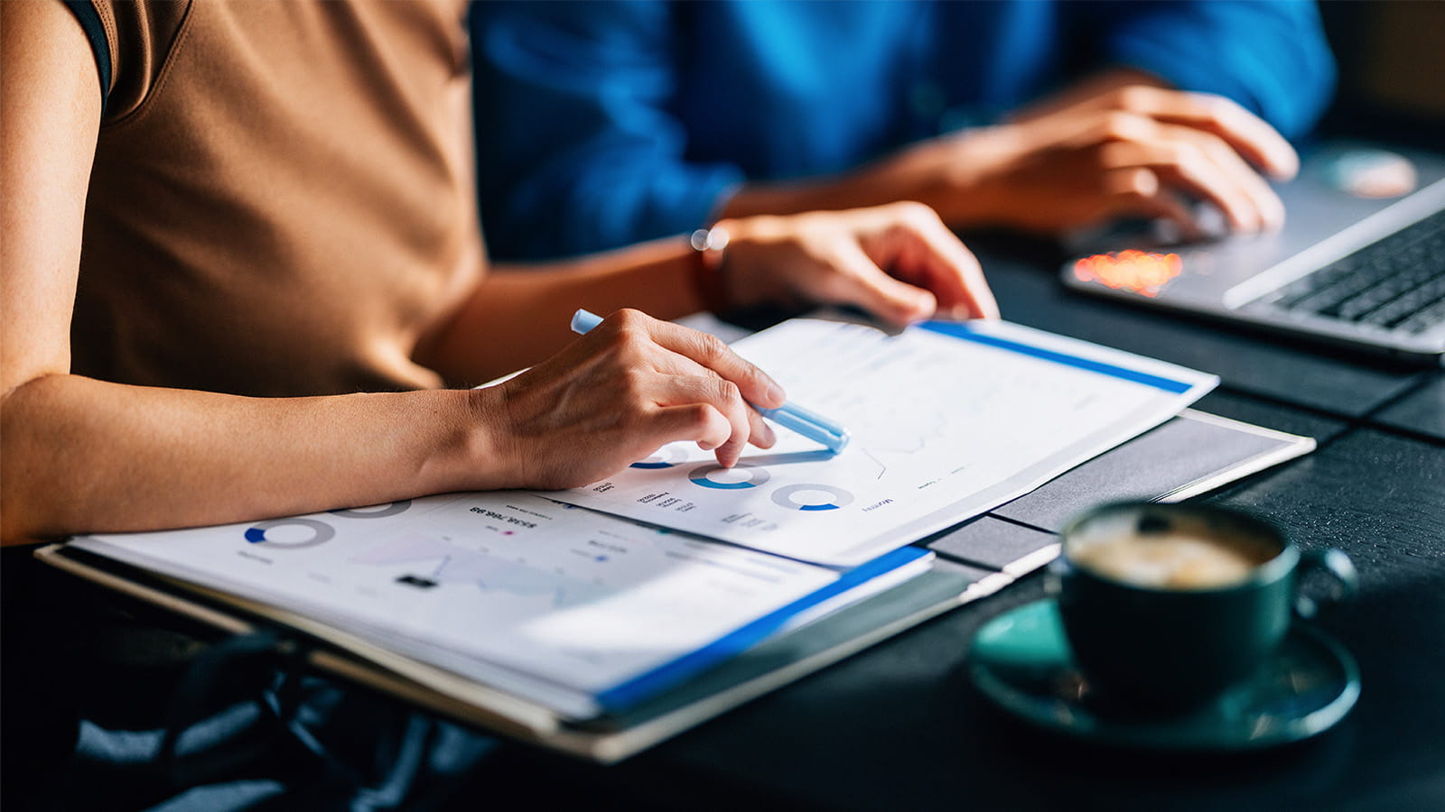 office work meeting employee colleagues hands pointing at charts graphs finance talking