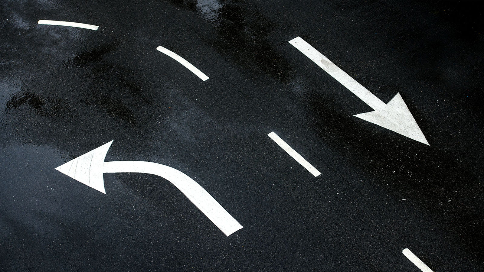 White arrows painted on a black road