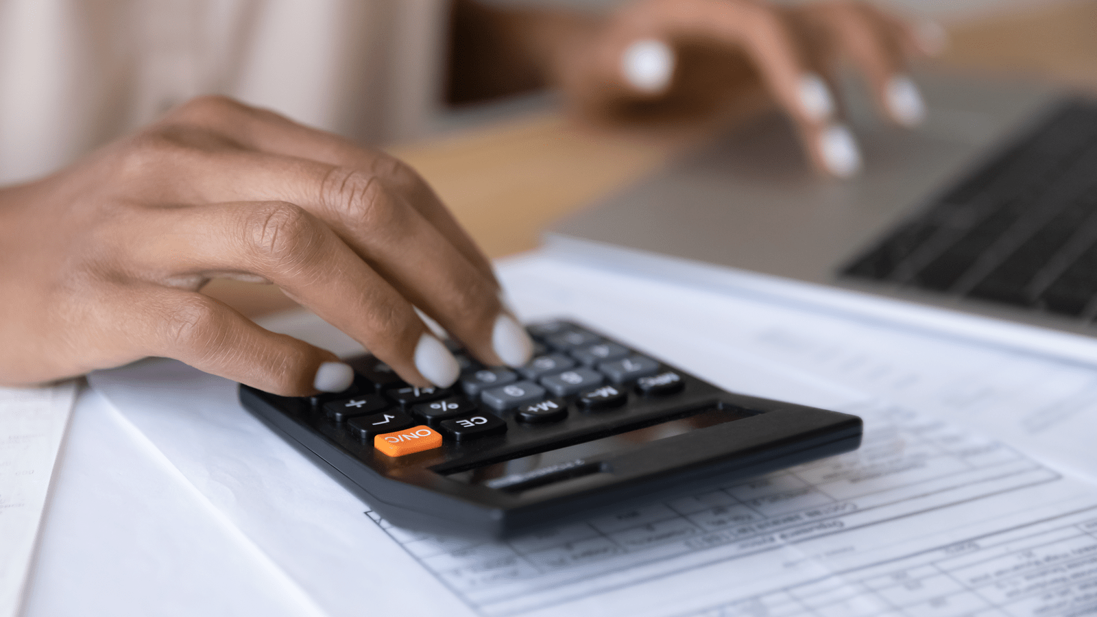 Hand typing on a calculator