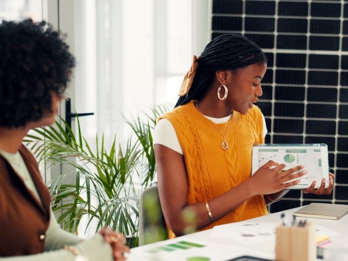 Office workers looking at report on a tablet