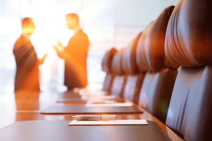 Two men in a business meeting silhouetted against a window