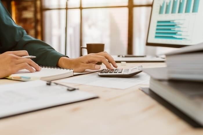 Close up of hands, calculator and paperwork