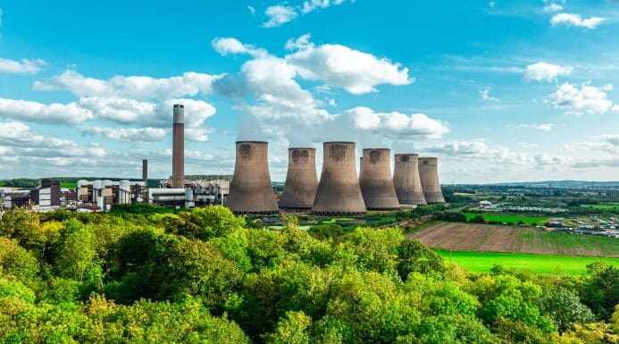 Power station with cooling towers rising above the trees in the East Midlands countryside