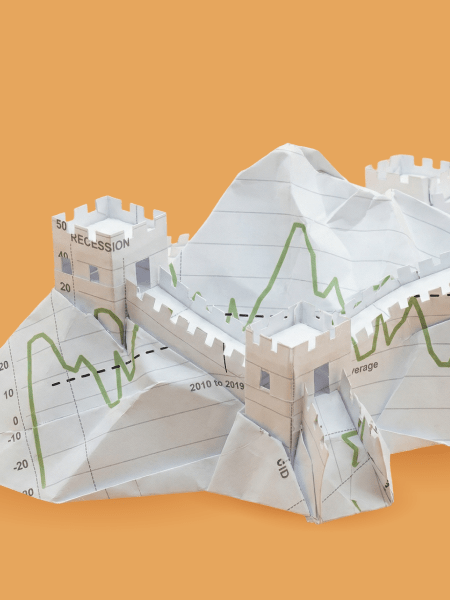 A paper sculpture resembling the Great Wall of China, folded from sheets printed with economic graphs and trend lines, symbolising China’s economy and market volatility.
