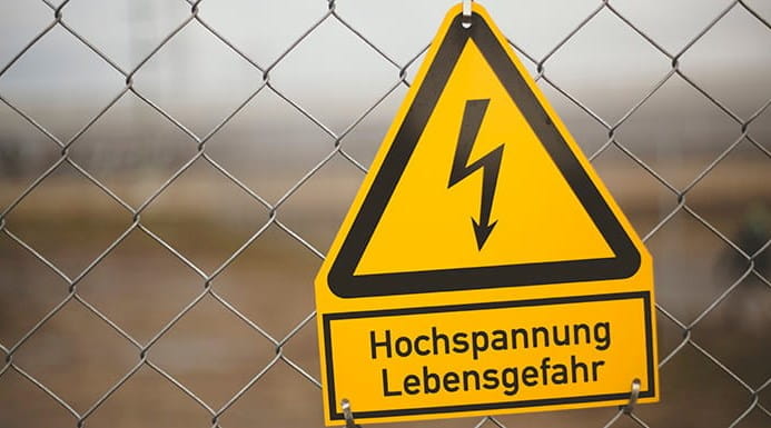 Electricity danger sign on a chain link fence