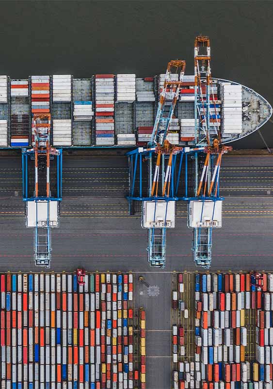 cargo trade ship seen from above aerial birds eye view shipping containers being loaded by cranes at a dock