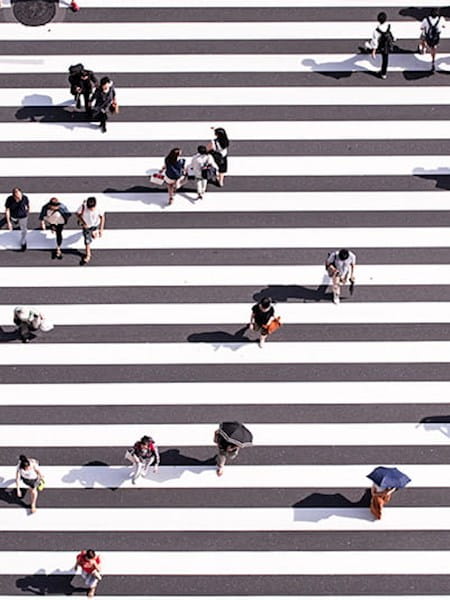 Aerial shot of people walking on a large zebra crossing