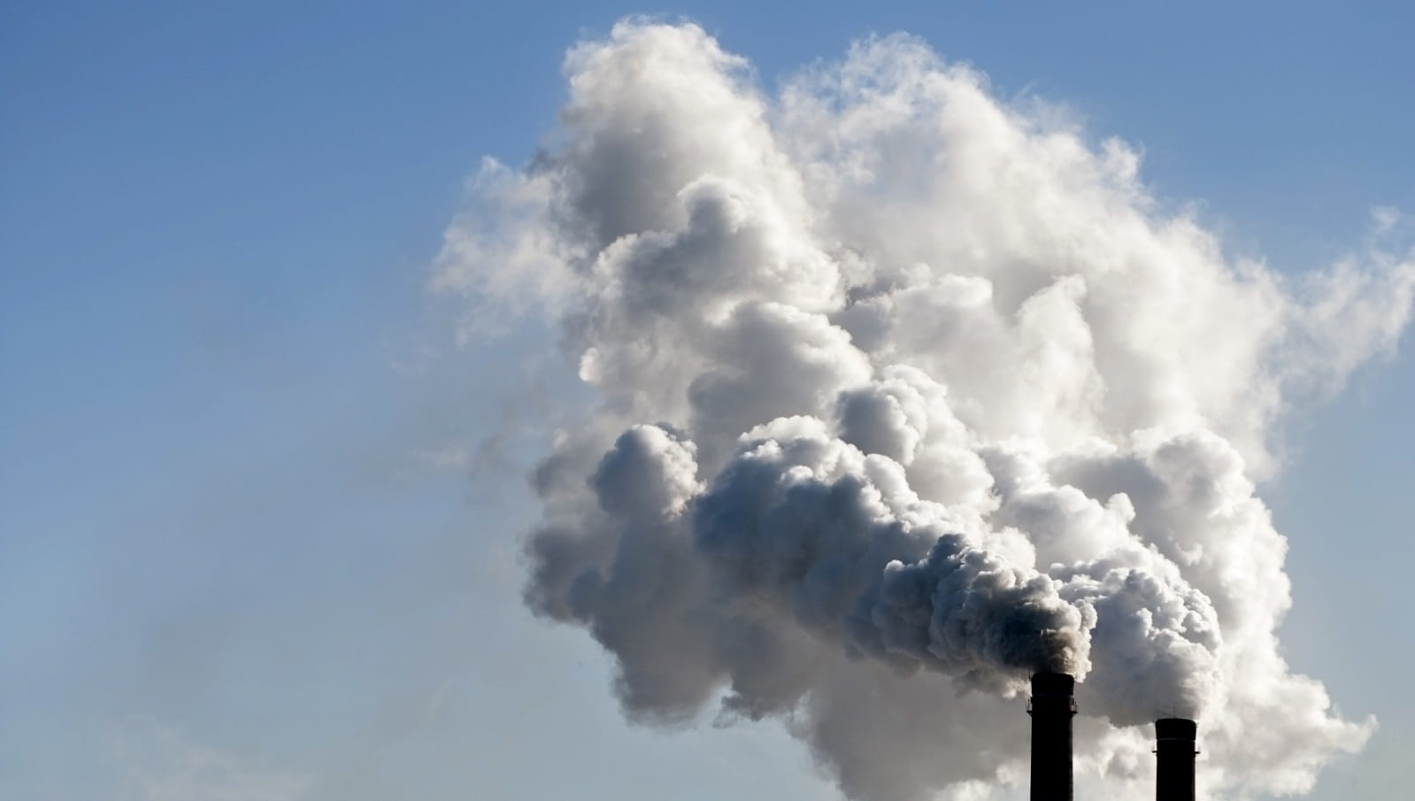 Two chimneys billowing smoke
