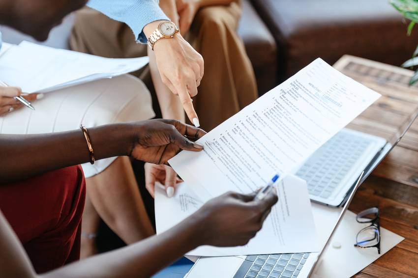 multi-ethnic businesswomen checking information in documents