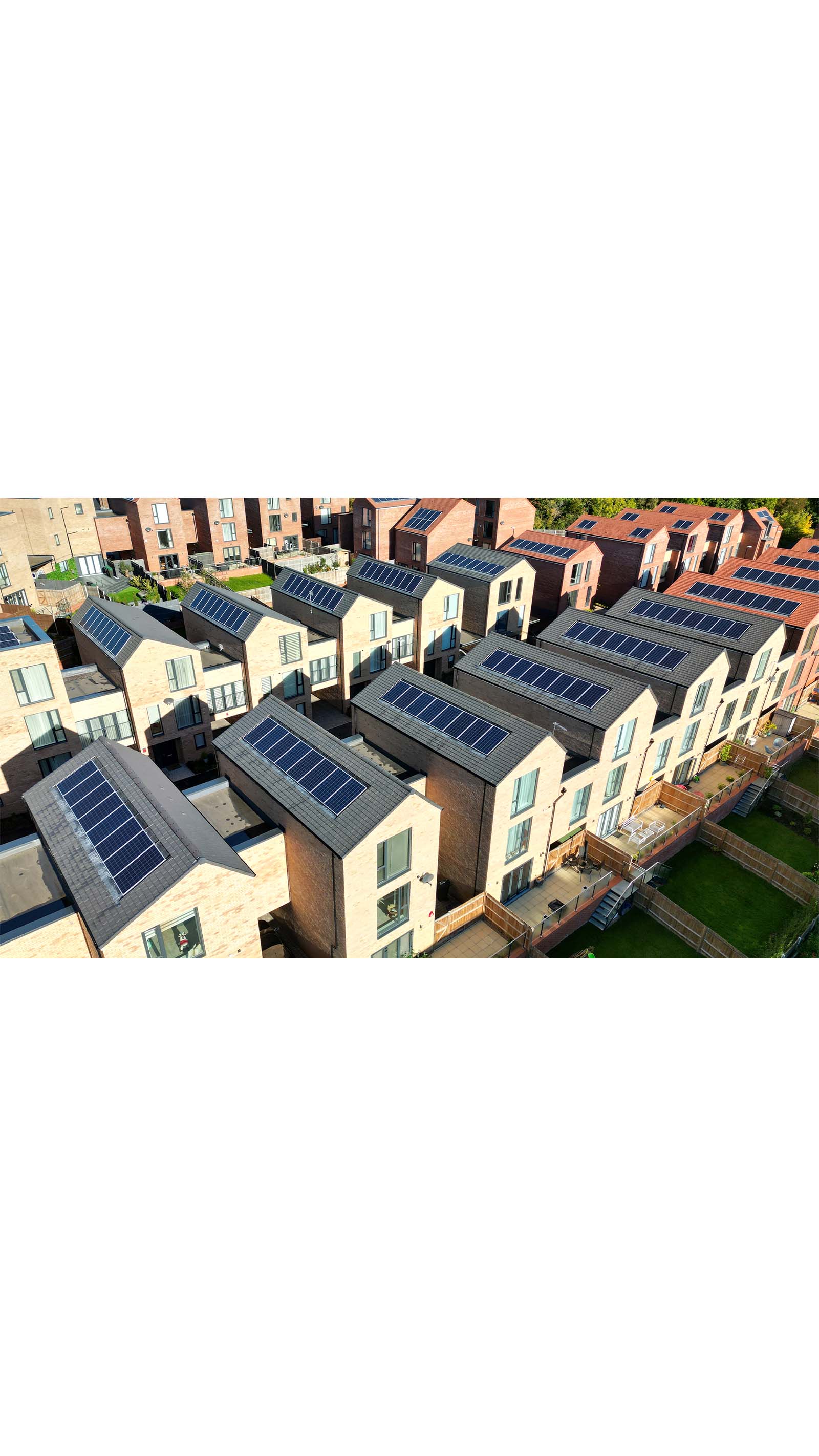 city rows of modern houses homes townhouses light beige brick grey roof solar panels