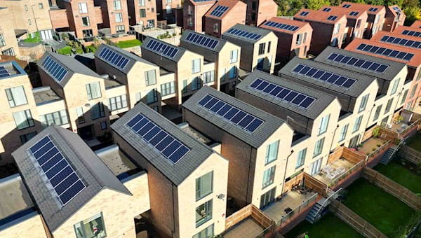 city rows of modern houses homes townhouses light beige brick grey roof solar panels
