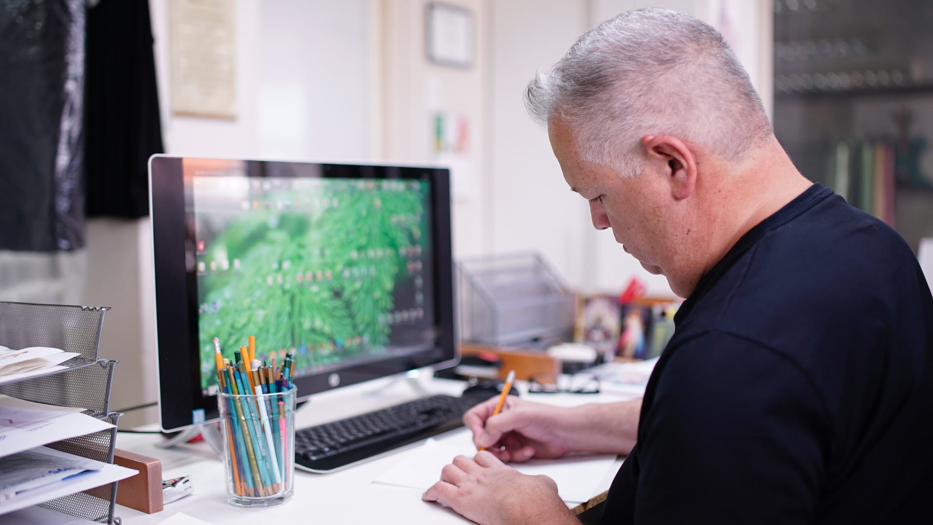 Men at desk with pencils