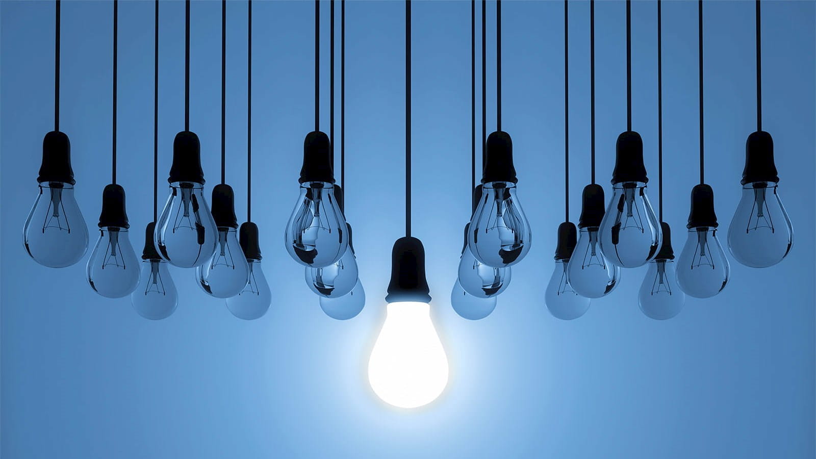 light bulbs glow hanging black cables blue background