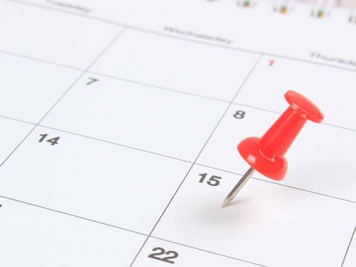 red pin pointing to a white calendar dates numbers 15