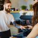 A male barista taking a mobile payment