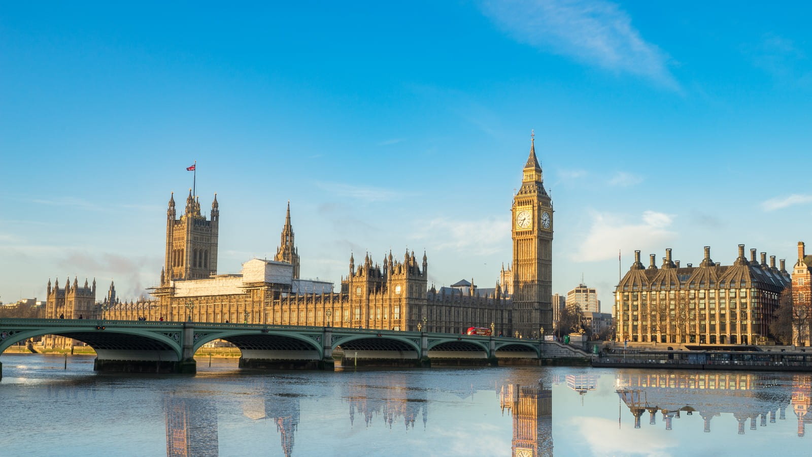 Big Ben and Westminster parliament with colorful sky and water reflection