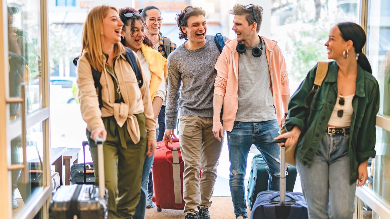 Young happy group travelling with suitcases