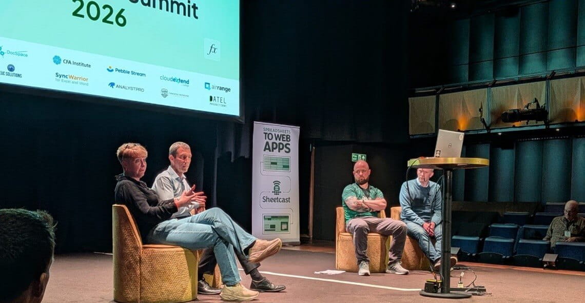 Four people sitting on chairs on stage having a discussion