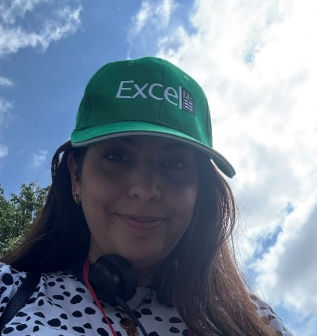 a poor photograph of women with an Excel  baseball cap