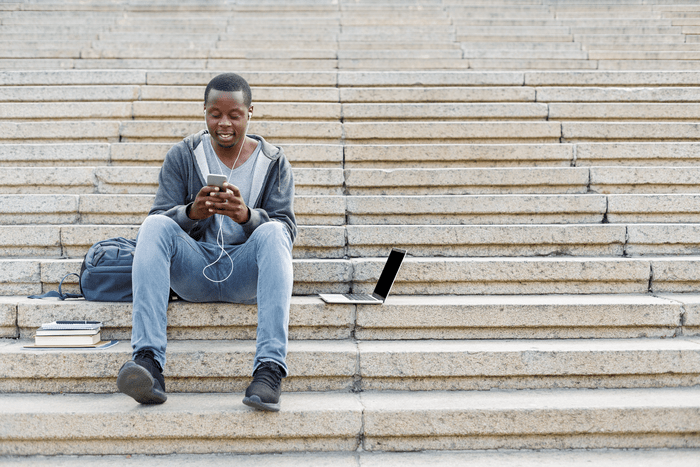 Man sitting on steps looking at mobile phone