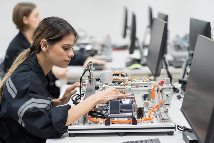Young female engineer building a computer