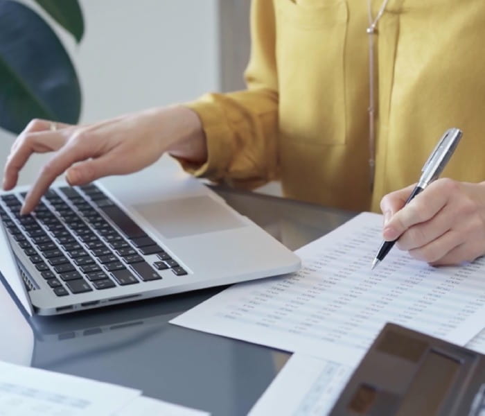 Women in yellow top doing accounts